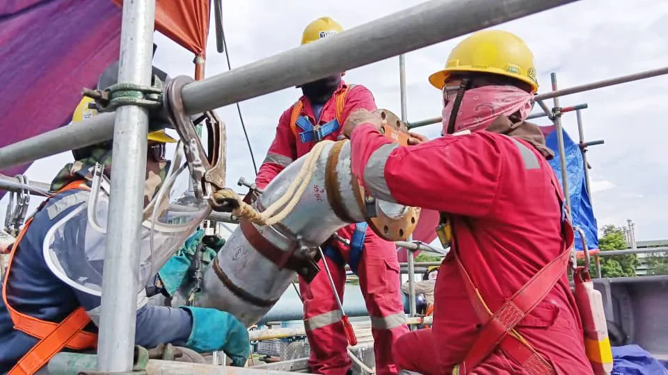Pipefitters installing a pipe spool at height